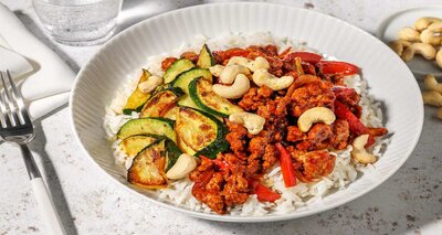Kung Pao-stijl bowl met kip en kalkoen met rijst, cashewstukjes en courgette