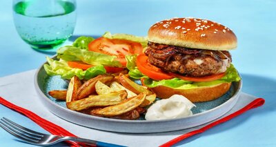 Cheeseburger met cheddar en tomaat met gebakken aardappeltjes en sla